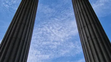 Zwei Säulen ragen in bewölkten Himmel.