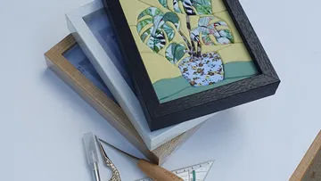 Gerahmte Kunst mit Werkzeugen auf weißer Oberfläche.
