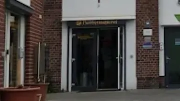 Entrance of a brick building, text visible.