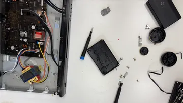 Electrical device opened for repair on table.