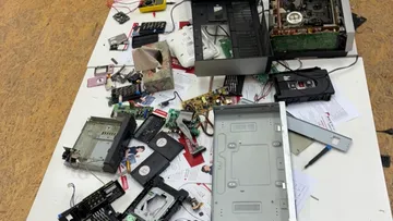 Electronics disassembled on a messy table.