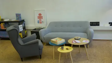 Wohnzimmer mit Sofa, Tisch, Spiele.