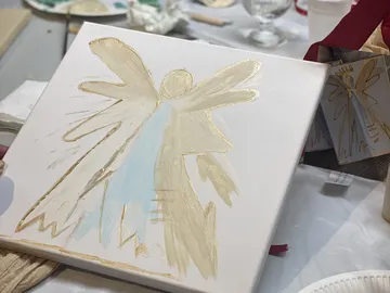 Canvas painting of an angel on a table.