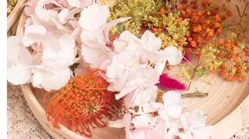 Flowers arranged in a wooden bowl.