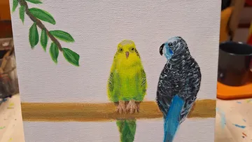 Two budgies sit on a painted branch.