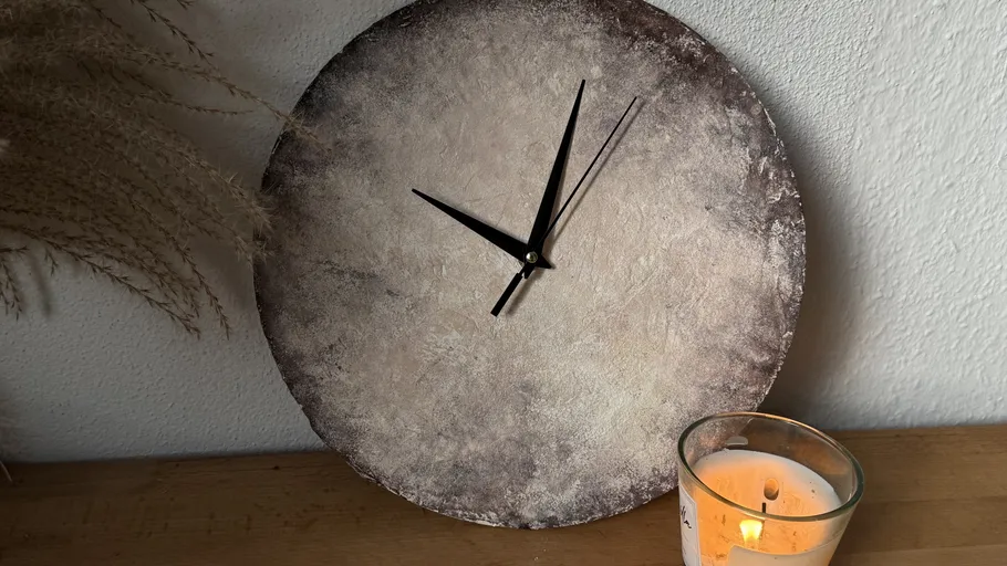 Abstrakte Wanduhr auf Holztisch ruhend.