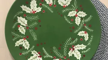 Teller mit Weihnachtsmotiv und Stechpalmen.