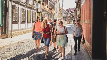 Gruppe geht auf Kopfsteinpflasterstraße in Stadt.