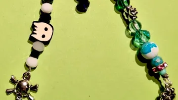 Perlenarmbänder mit Totenkopf und Planeten-Anhängern.