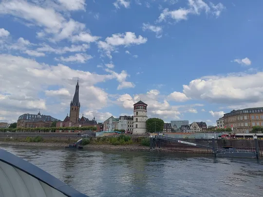 Stadtansicht am Fluss mit Kirche und Turm.