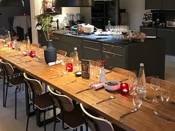 Langer Holztisch mit gedecktem Essen in moderner Küche.
