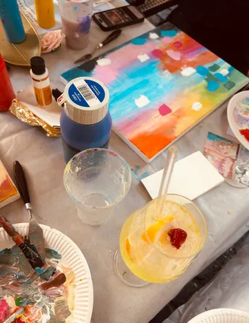 Colorful painting on a cluttered art table.