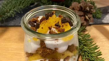 Dessert jar with chocolate on table.