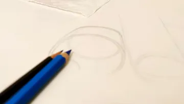 Zwei Bleistifte liegen auf einem Skizzenbuch.