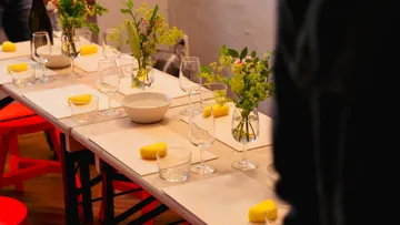 Table set with glasses, flowers, and yellow sponges.