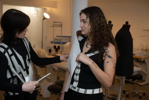 Zwei Designer diskutieren Kleidung im Studio.