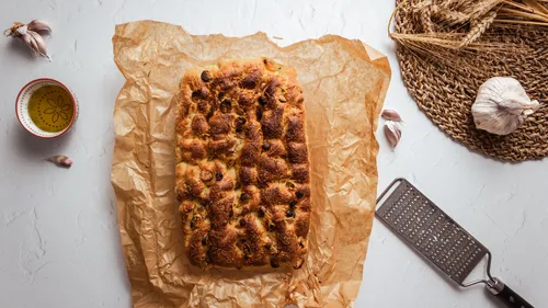 Focaccia-Brot auf Pergament mit Knoblauch.