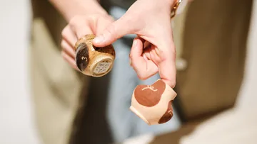 Hände halten Holz-Salz-und-Pfeffermühlen.