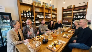 People enjoying wine and cheese tasting indoors.