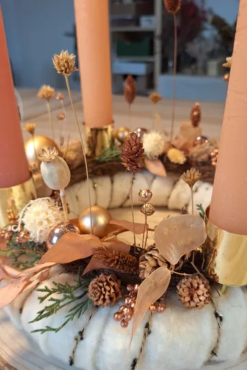 Candle centerpiece with dried flowers and leaves.