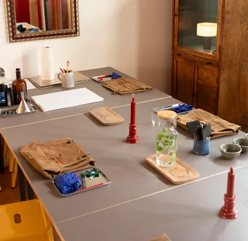 Basteltisch mit roten Kerzen, Material organisiert.