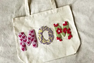Canvas bag with 'MOM' in colorful embroidery.