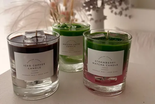 Drei Kerzen in Gläsern auf einem Tisch.