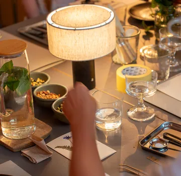 Tisch mit Lampe, Snacks, und Hand greifend.