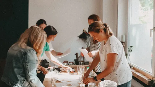 Women work together at a table in a modern room.