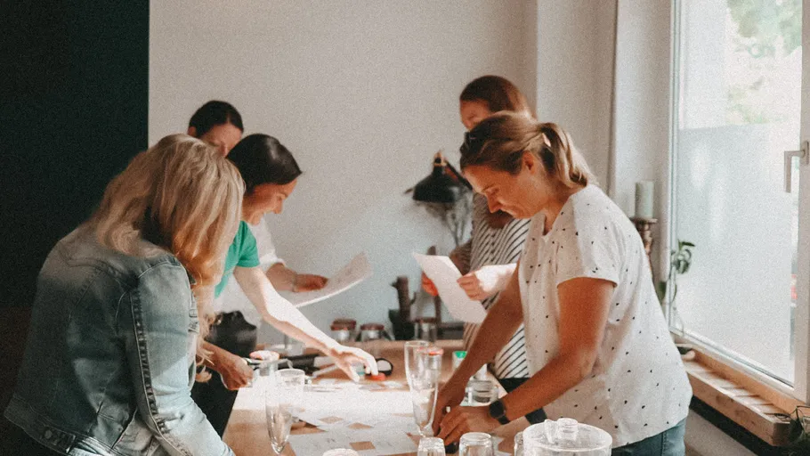 Women work together at a table in a modern room.