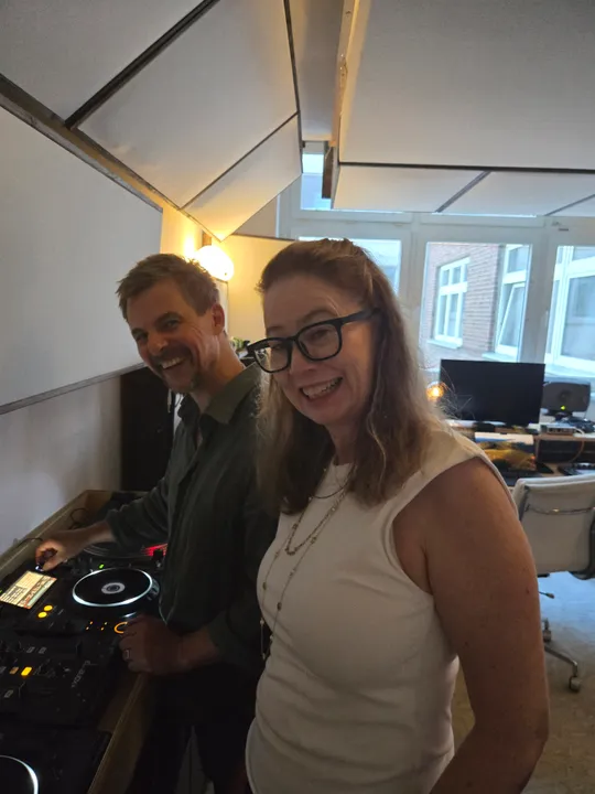Zwei Personen lächeln im Tonstudio.