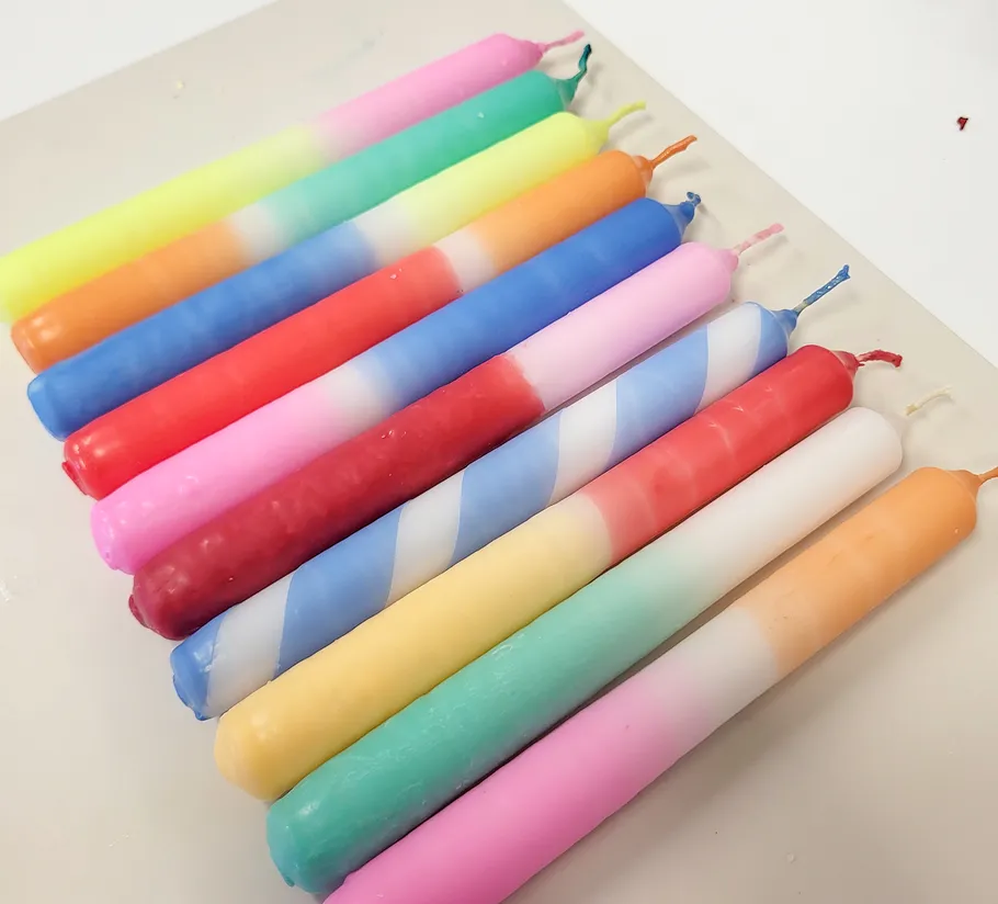 Colorful candles arranged on a white surface.