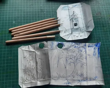 Pencils on grid paper with drawings.