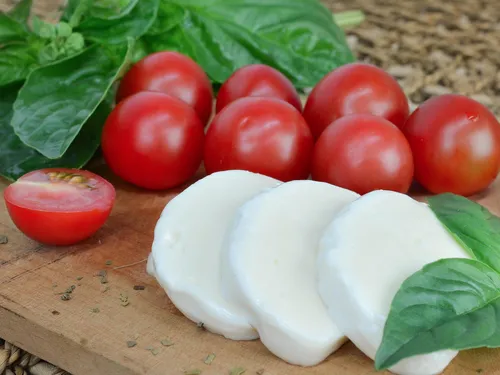Fresh tomatoes and mozzarella on a wooden board.