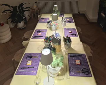Basteltisch mit Materialien, heller Raum.