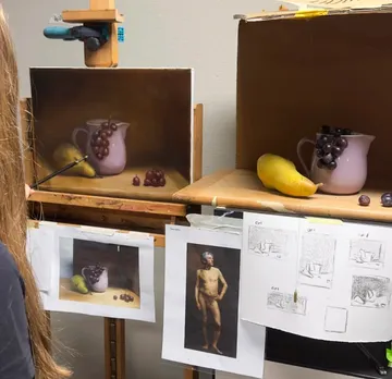 Painting student observing still life setup.