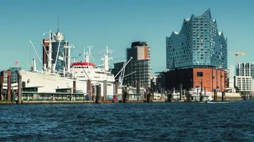 Schiff neben modernen Ufergebäuden angedockt.