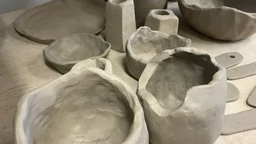 Verschiedene Tontöpfe und Schalen auf einem Tisch.