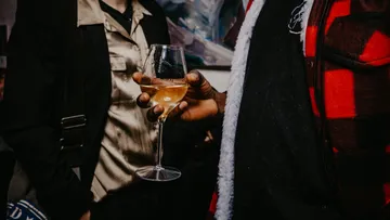 Hand holding wine glass at event.