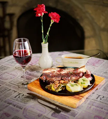 Steak mit Wein in gemütlichem Restaurant serviert.