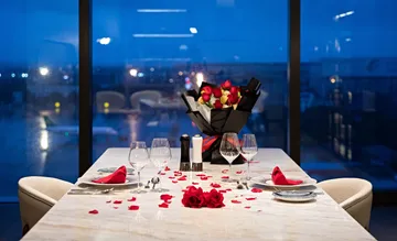 Tisch für romantisches Abendessen mit Rosen gedeckt.