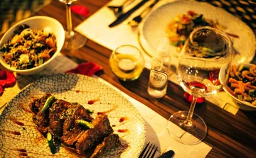 Dinner plates with gourmet food on table.