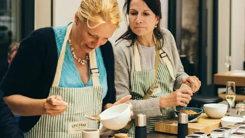 Two women preparing food in a kitchen.