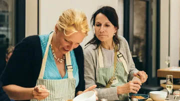 Two women cooking in a kitchen.