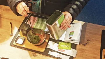 Person mixing spices on wooden table.