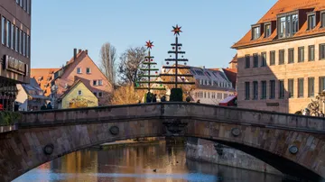 Brücke mit Christbäumen geschmückt, städtische Umgebung.