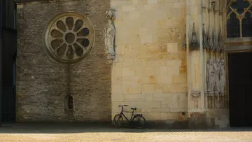 Fahrrad vor historischer Kirchenwand geparkt.