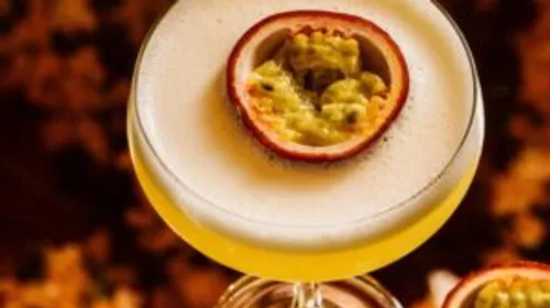 Cocktail with passion fruit garnish on top.