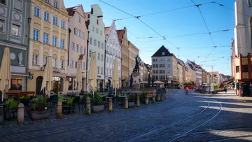 Straßenansicht mit Straßenbahnschienen, Außensitzplätze.