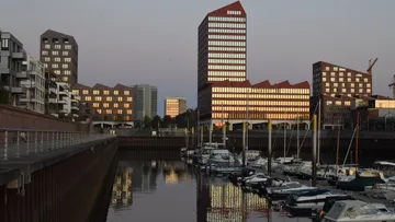 Gebäude spiegeln sich in einem Hafen.
